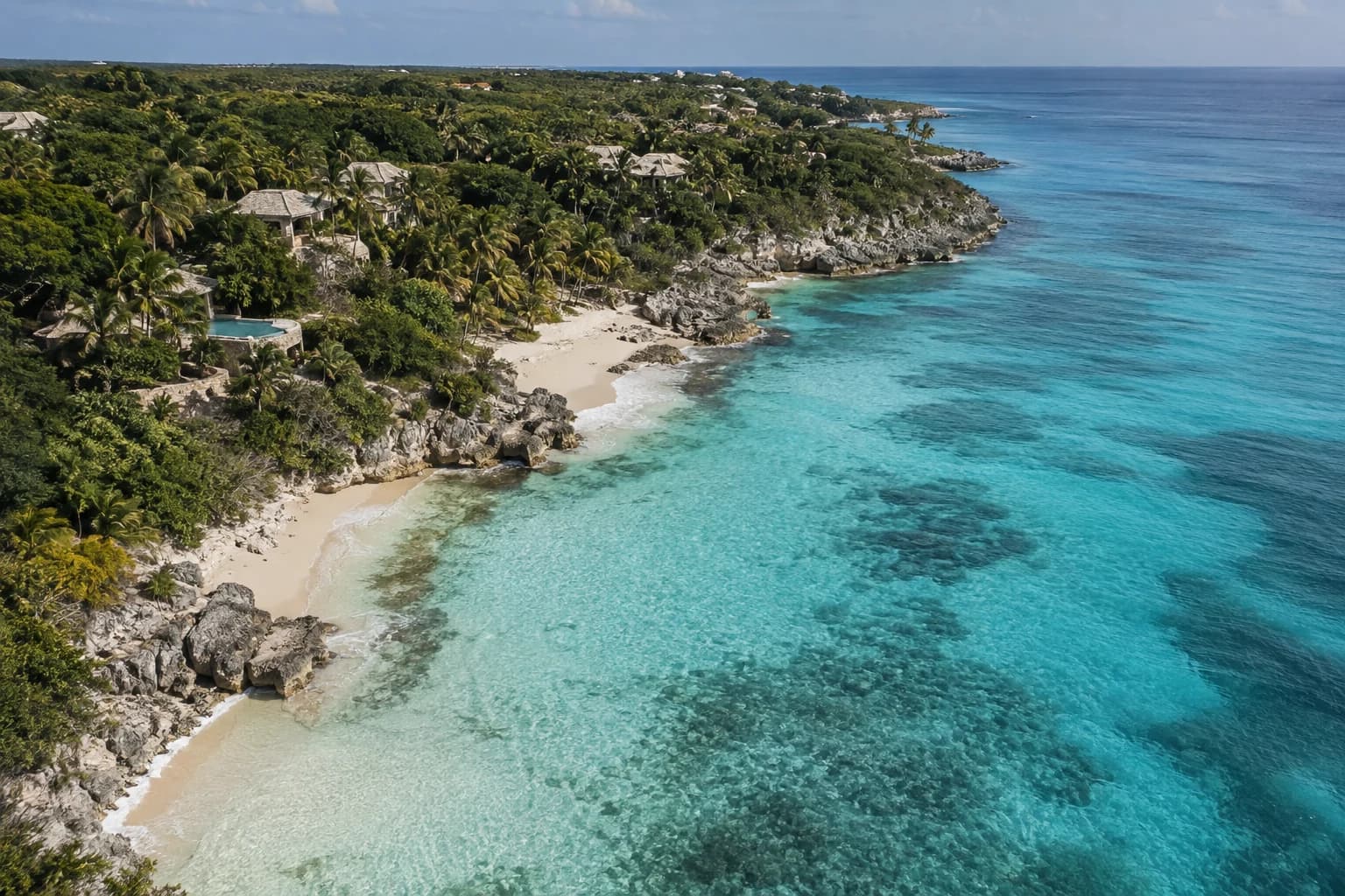 A reef-blue Caribbean cove with intimate hotel pavilions hidden among palms