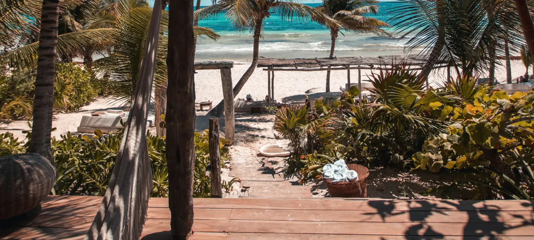 A palm-framed path from a small tropical hotel to the sea